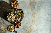 From above bowls with different kinds of nuts on concrete table background