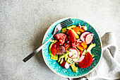 Seasonal summer vegetable salad with avocado and sesame seeds served in the ceramic bowl