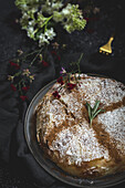 Appetitliche Bastilla mit aromatischen Gewürzen auf dem Tisch in der Nähe eines Blumenzweigs während des Ramadan-Festes