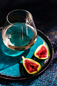 Glass of cold white dry wine and fig fruit halfs as a appetizer before dinner