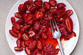 Sugar-coated sliced strawberries on a plate. Cooking dessert or jam