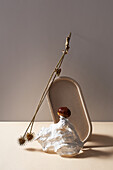 Still life composition with dried twig placed on table with dried twig and chestnut on stone against gray background in studio