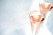 Rosensekt oder Champagner in Kristallgläsern auf hellem Hintergrund an einem sonnigen Tag