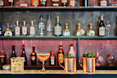 Moscow Mule und saure Cocktails werden in einem Glas mit Eiswürfeln auf dem Tresen einer Bar serviert