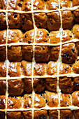 Top view full frame background of delicious baked homemade hot cross buns with cream and raisin