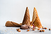 Upside down waffle cones with ice cream on concrete background