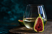 Glass of cold white dry wine and fig fruit halfs as a appetizer before dinner