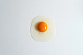 Top view of fresh raw chicken egg placed on white background in bright studio