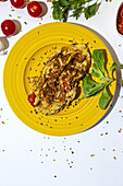 Delicious omelette with chopped parsley on plate against sun dried tomatoes on white background