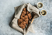 Cup of coffee and chocolate cookies in the box for breakfast on concrete background