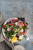 Organic vegetable salad with seasonal vegetables and herb mix with seeds and lemon in a bowl