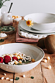 Bowl with fresh fruits and berries over rustic wooden table