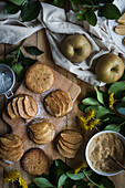 Süße Kekse mit Apfelscheiben auf dem Tisch und Schneidebrett neben Löwenzahn