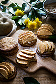 Sweet cookies with slices of apples placed on table and cutting board near dandelions