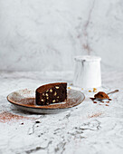 Vorderansicht eines Stücks Brownie-Kuchen auf einem Teller vor weißem Marmorhintergrund