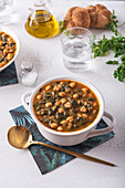 Schale mit leckerer Kichererbsensuppe zum Mittagessen auf Papierserviette neben Löffel