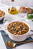 High angle of bowl with tasty chickpea soup served for lunch on paper napkin near spoon