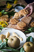 High angle of anonymous person taking delicious apple tartlet from table in kitchen at home