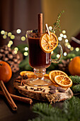 Gluhwein or christmas punch mulled wine server on a glass mug with dried orange slices