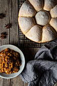 Top view of tasty homemade soft bread buns and sauce in plate served on wooden table