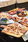 From above of assorted tasty appetizers served on table with tablecloth on terrace