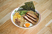 Stock photo of yummy ramen soup with boiled egg and meat in japanese restaurant.