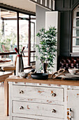 Wooden counter with various kitchenware placed in stylish restaurant with big glass windows in daytime