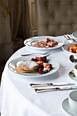 Various colorful dishes and juices served on round table during breakfast in elegant hotel restaurant in sunny morning