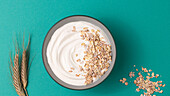 From above yoghurt served with dried oats on blue background