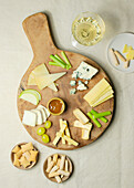 Von oben verschiedene Käsescheiben auf einem Holzbrett mit Croutons auf dem Tisch