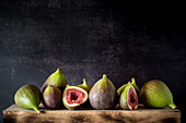 Ripe halved and whole figs placed on wooden rustic table