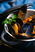 Delectable mussels with herbs in metal saucepan