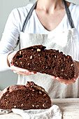 Crop faceless woman hands holding freshly baked sourdough rye bread Crumb pan cutting in half