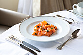 From above of tasty appetizing sliced smoked salmon served in plate with capers and herbs in elegant restaurant