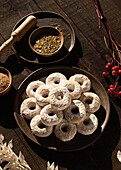 Draufsicht auf Christmas Wine Donuts auf einem Holztisch umgeben von Zutaten