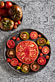 Top view of delicious sliced tomatoes in cast iron plate placed on concrete table