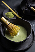 Von oben gesehen traditioneller japanischer Matcha mit Teebesen in einer Steinschale für eine traditionelle orientalische Zeremonie