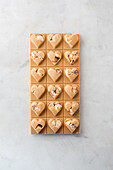 Top view of delicious candies with nuts in shape of heart on marble table background