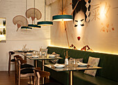 Cozy interior of Asian restaurant with comfortable sofa and glass tables served with tableware