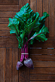 From above of bunch of beet placed on black shabby background in studio