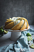 Tasty lime sponge cake served on white plate near flowers and lime slices