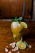 Crystal glass of Mojito cocktail made of rum mixed with sugar lime juice and soda water garnished with mint leaves