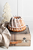 Delicious homemade cake on vintage suitcase against white background