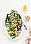 From above delicious prosciutto, mozzarella and asparagus salad on white table background