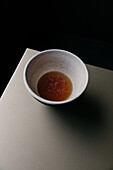 From above of porcelain bowl with soy sauce in restaurant