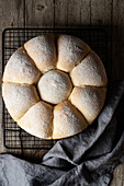 Appetizing soft bread buns on baking tray placed on wooden counter