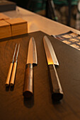 Sharp knives placed on wooden table in Asian restaurant