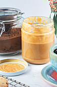 Still life of glass jars with peanut butter and chocolate powder