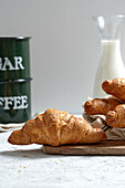 Delicious croissants and bottle of milk placed on table for breakfast in kitchen