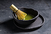 From above of traditional Japanese matcha with tea whisk in stone bowl for traditional oriental ceremony
